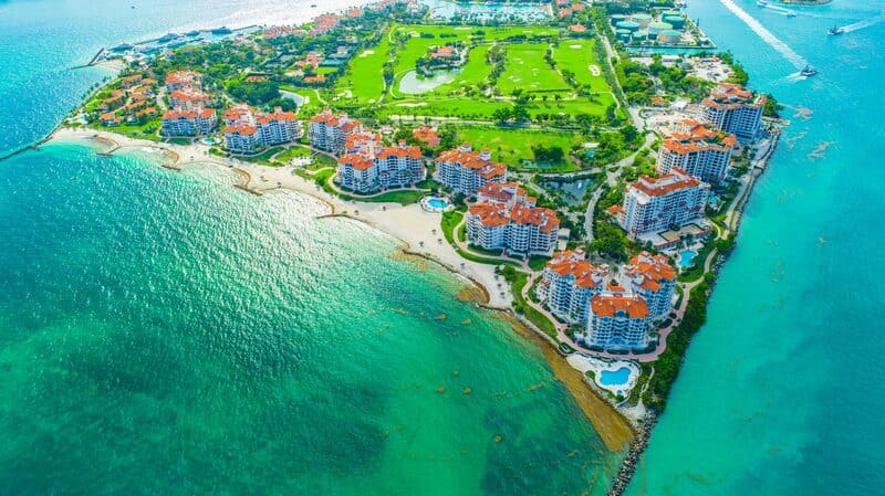 Aerial view of Fisher Island luxury condos and private beaches from a Miami sightseeing boat tour.