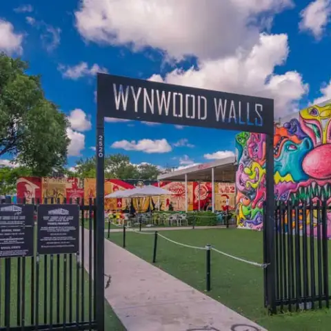 Entrance to Wynwood Walls with vibrant murals and blue sky.